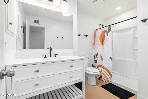 a bathroom with a sink a toilet and shower