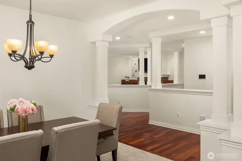 a dining room with furniture a chandelier and wooden floor