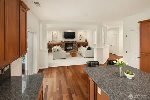 a kitchen with stainless steel appliances a refrigerator a sink a stove a microwave and wooden floors