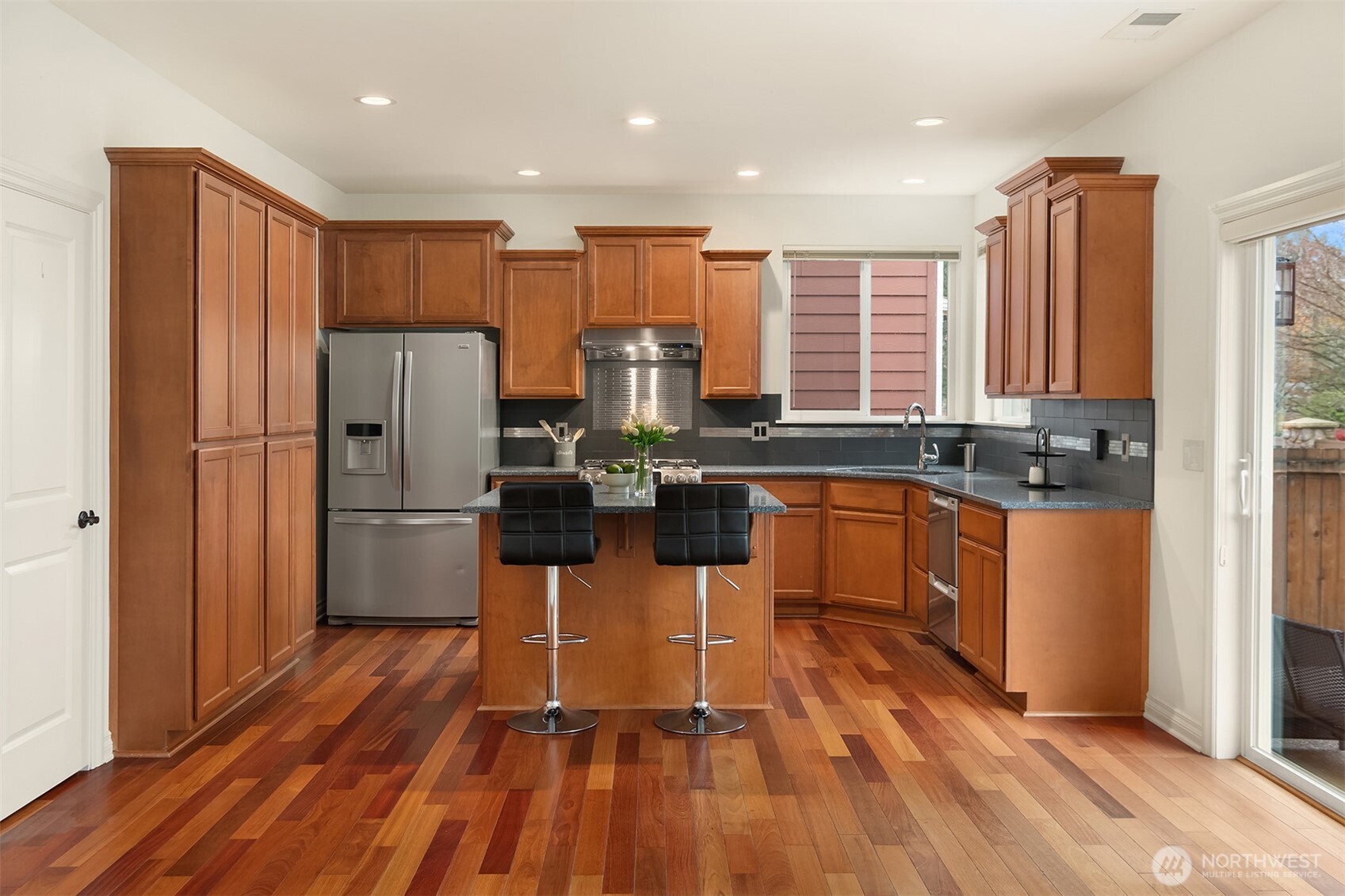 787 Hoquiam Place Northeast Renton, WA 98059 - Photo 21 of 36 a kitchen with stainless steel appliances a refrigerator a sink a stove a microwave and wooden floors