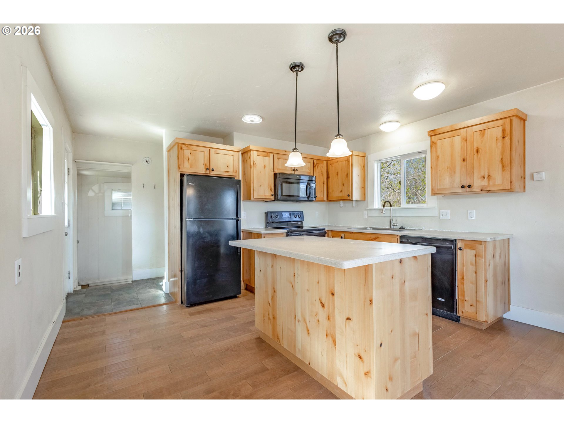 342 Southeast 7th Street Madras, OR 97741 - Photo 3 of 22 a kitchen with stainless steel appliances granite countertop a refrigerator a sink a stove and a wooden floors