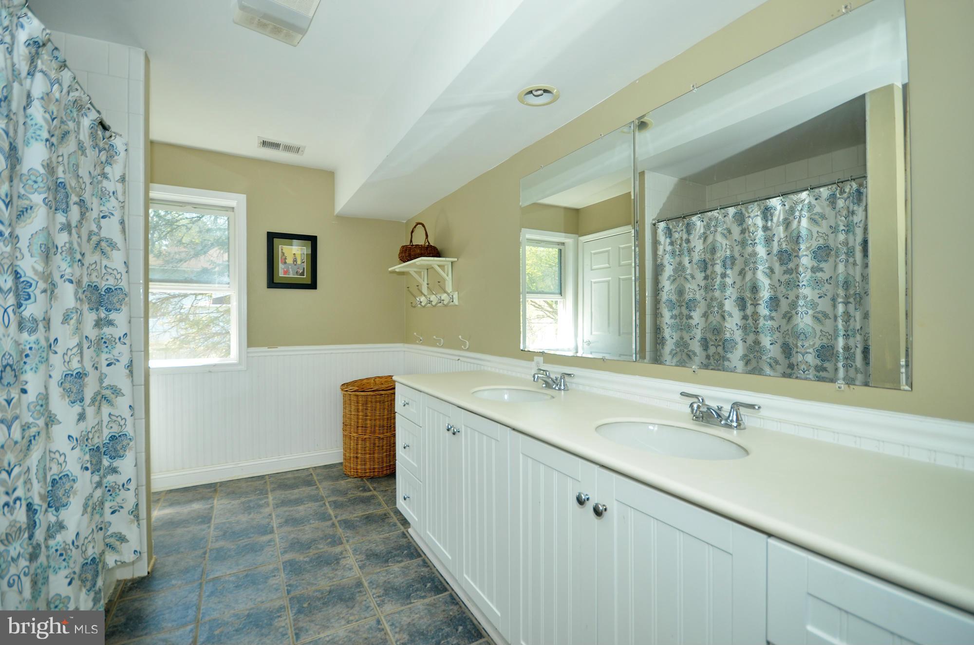 8010 Rider Avenue Baltimore, MD 21204 - Photo 12 of 29 a spacious bathroom with a granite countertop sink mirror and a bathtub