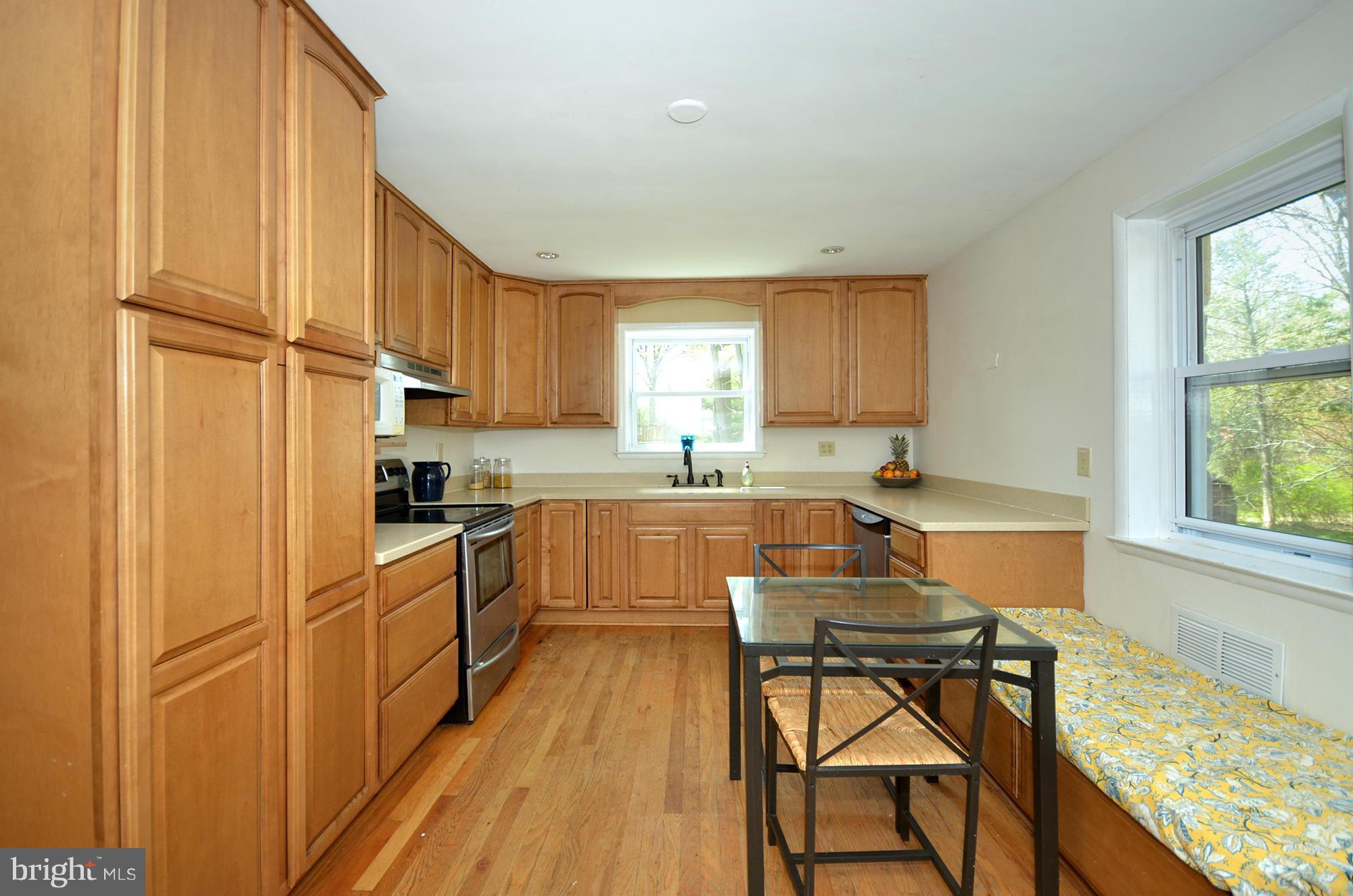 8010 Rider Avenue Baltimore, MD 21204 - Photo 3 of 29 a kitchen with granite countertop wooden floors and white stainless steel appliances