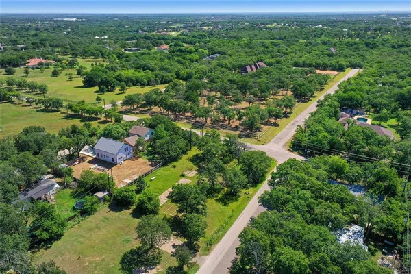 an aerial view of green landscape with trees houses and mountain view
