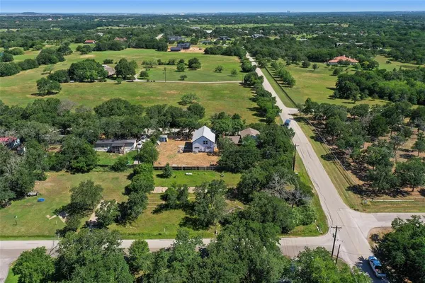 an aerial view of residential houses with outdoor space and trees
