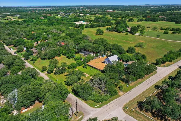 an aerial view of residential houses with outdoor space and trees