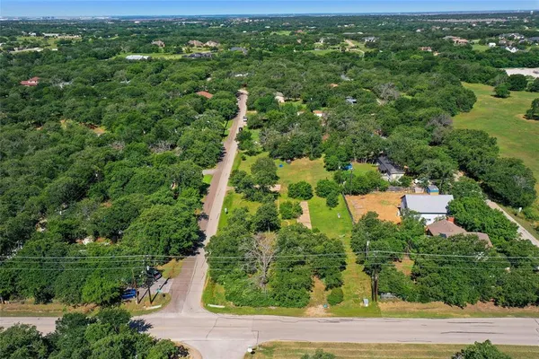 an aerial view of residential houses with outdoor space and trees