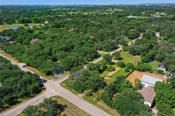 an aerial view of residential houses with outdoor space and trees