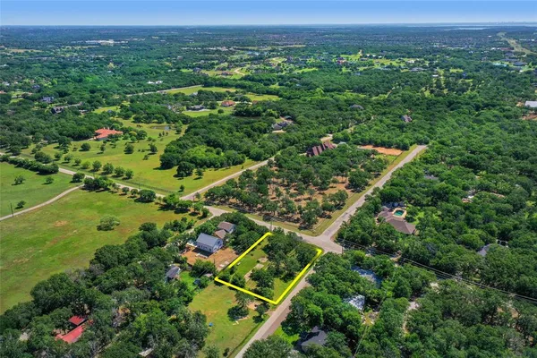 an aerial view of residential houses with outdoor space and trees