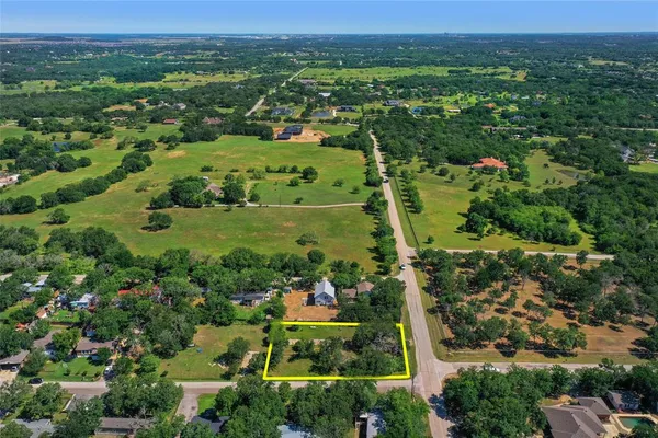 an aerial view of residential houses with outdoor space and trees