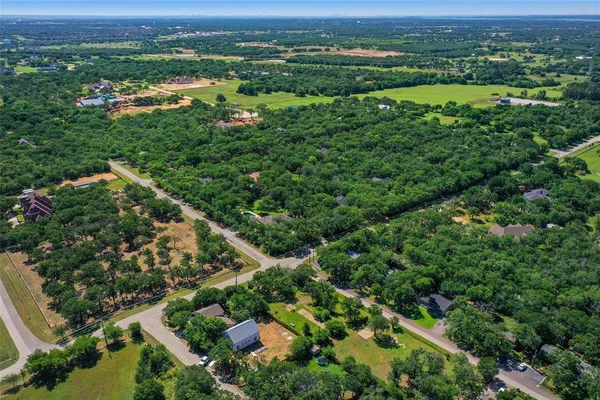 an aerial view of residential houses with outdoor space and trees