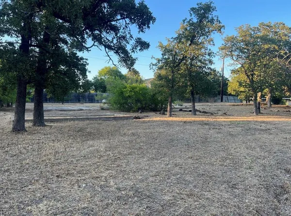 a view of dirt yard with a trees