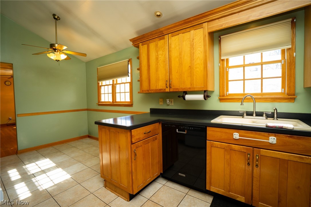 453 Omar Street Struthers, OH 44471 - Photo 13 of 27 Kitchen with a peninsula, vaulted ceiling, dishwasher, wood finish cabinetry, and dark countertops