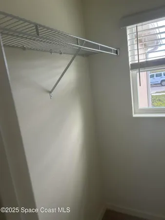 a view of a room with rack on the wall and a window