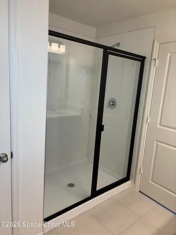 a bathroom with a glass door shower and vanity