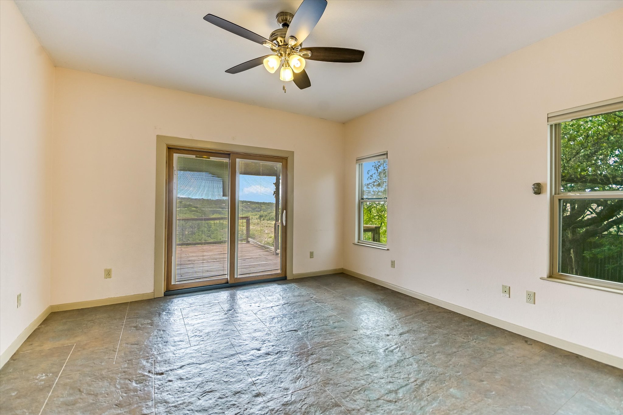 700 Cliffside Road Wimberley, TX 78676 - Photo 7 of 22 Interior space featuring textured flooring, a ceiling fan with integrated lighting, and multiple windows