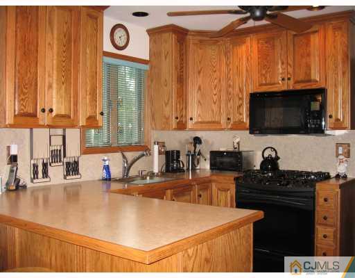 16 Surrey Road Somerset, NJ 08873 - Photo 4 of 8 a kitchen with granite countertop a sink a stove and a microwave