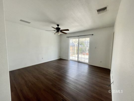 1304 South McCall Street Ridgecrest, CA 93555 - Photo 10 of 22 a view of empty room with wooden floor and fan