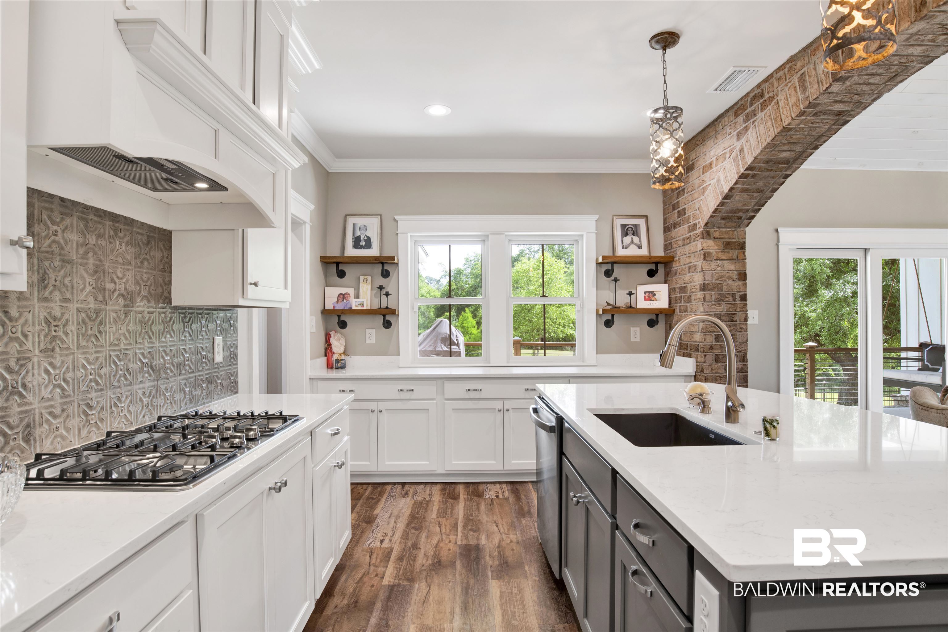 21621 Veranda Boulevard Fairhope, AL 36532 - Photo 23 of 51 Kitchen with open shelves, a sink, premium range hood, stainless steel appliances, and visible vents