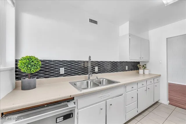 a kitchen with a sink and white cabinets