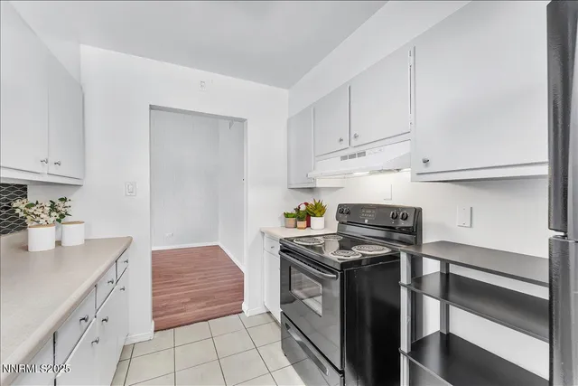 a kitchen with granite countertop a stove sink and cabinets