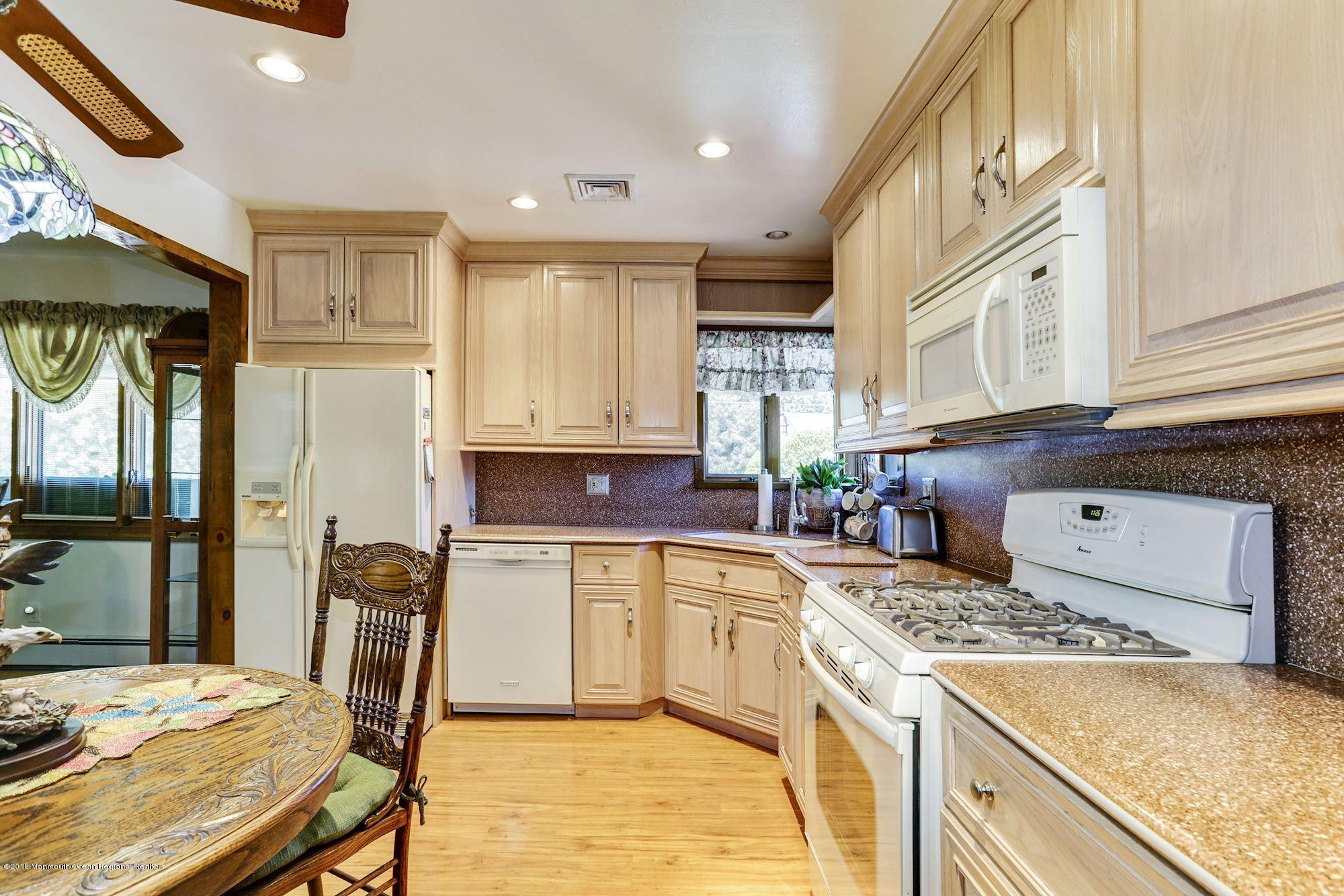 9 Kenmore Road Freehold, NJ 07728 - Photo 11 of 25 a kitchen with a stove a sink dishwasher and a refrigerator