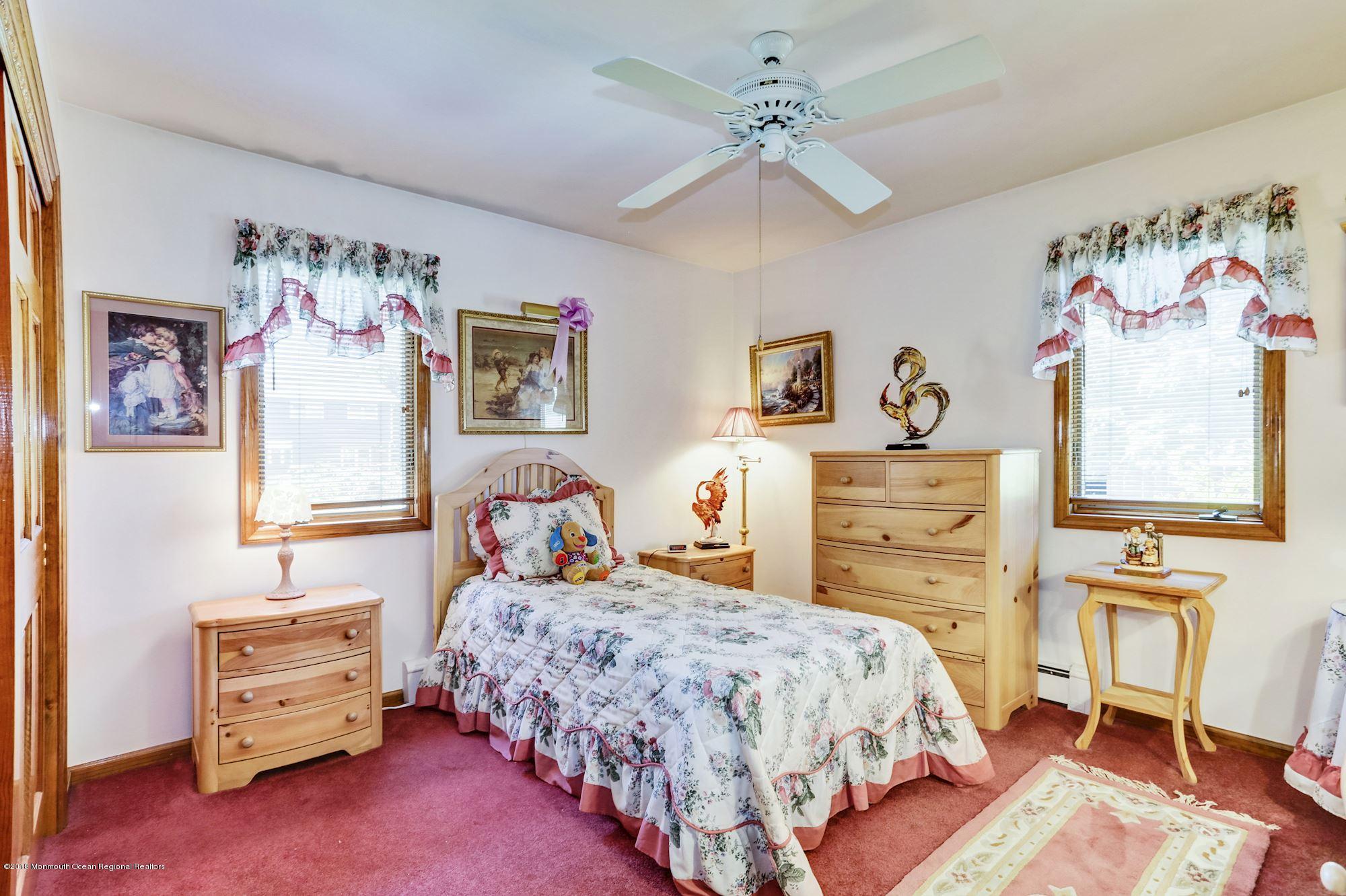 9 Kenmore Road Freehold, NJ 07728 - Photo 17 of 25 a bedroom with a bed and dresser with paintings on wall