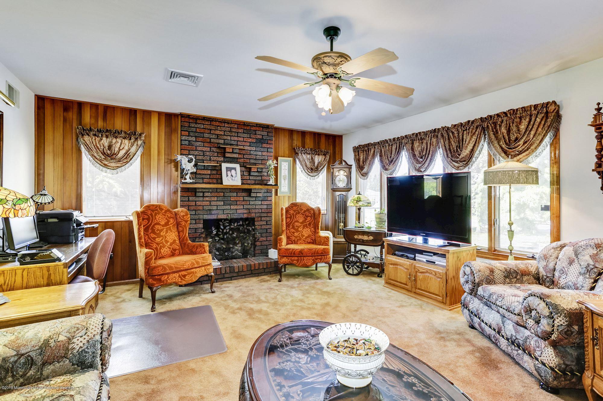 9 Kenmore Road Freehold, NJ 07728 - Photo 6 of 25 a living room with fireplace furniture and a flat screen tv
