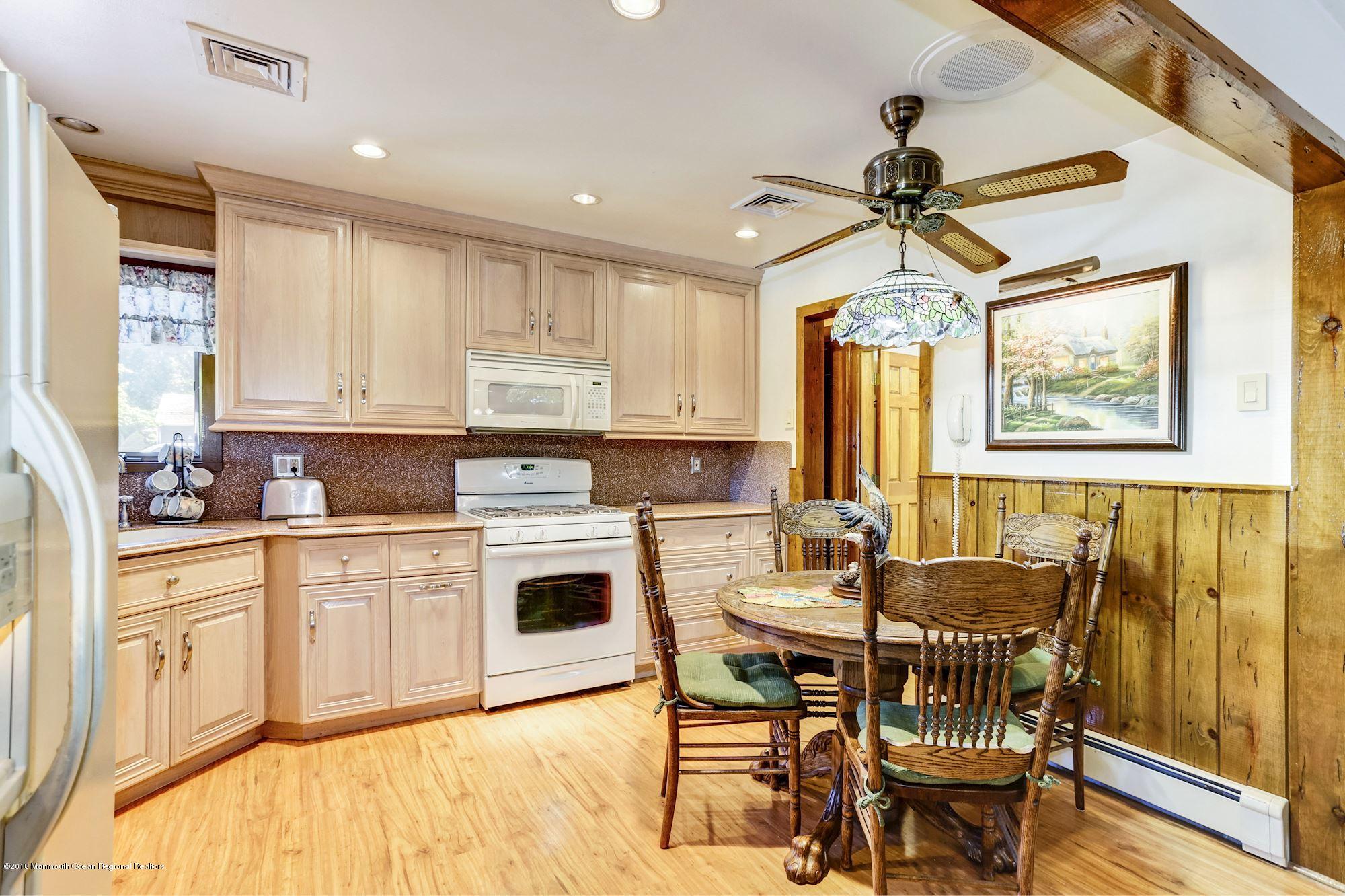 9 Kenmore Road Freehold, NJ 07728 - Photo 9 of 25 a kitchen with a dining table chairs and white cabinets
