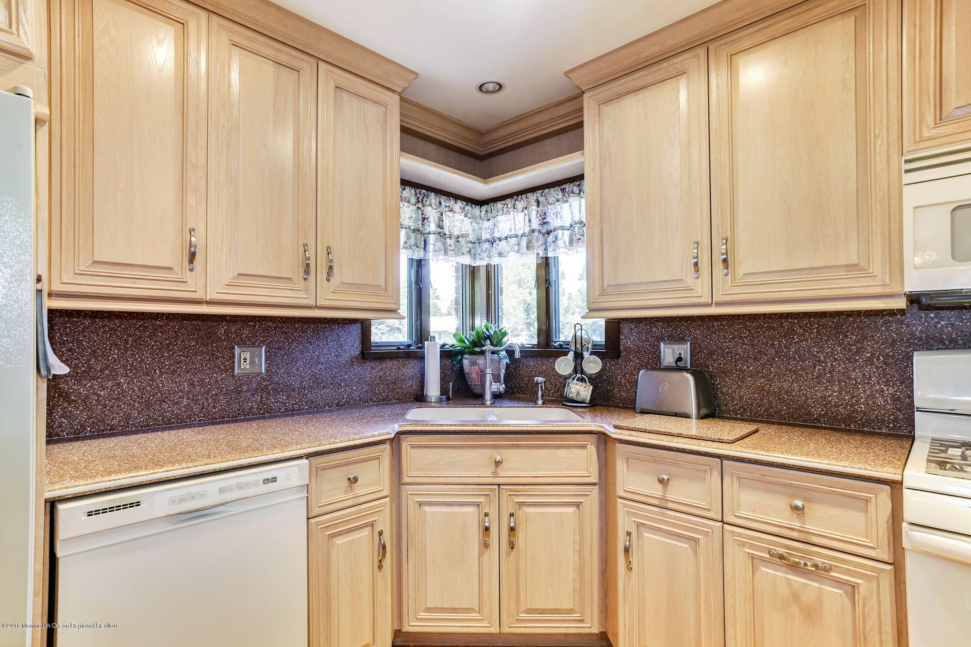 9 Kenmore Road Freehold, NJ 07728 - Photo 10 of 25 a kitchen with stainless steel appliances granite countertop white cabinets and a window