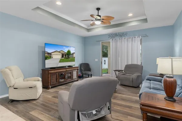 a living room with furniture kitchen view and a chandelier