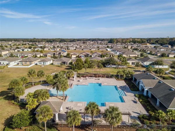 a view of a house with a swimming pool and sitting area
