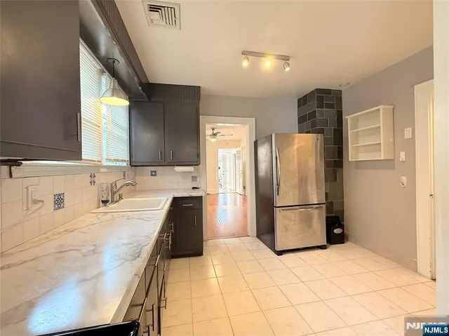 a kitchen with a refrigerator a sink and cabinets