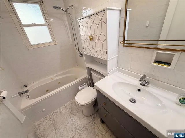 a bathroom with a sink mirror toilet and bathtub