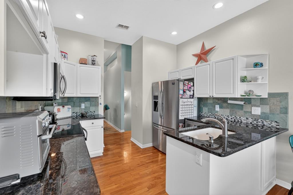 49 Loggerhead Court Ponce Inlet, FL 32127 - Photo 18 of 59 a kitchen with stainless steel appliances granite countertop a sink stove and refrigerator