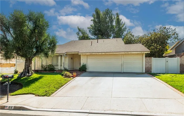a view of a white house with a yard and potted plants