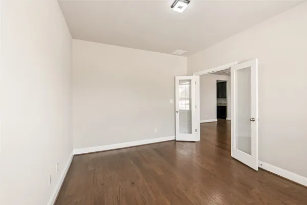 a view of an empty room with wooden floor