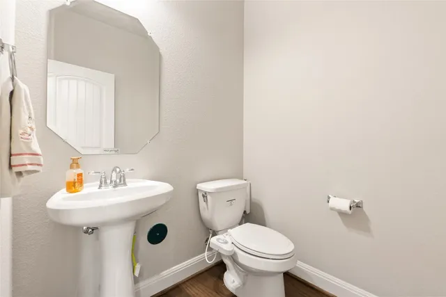 a bathroom with a sink and mirror with toilet