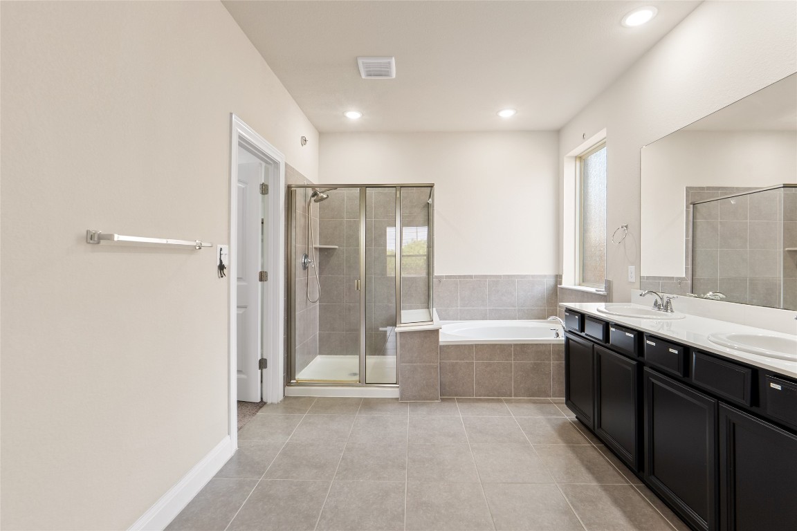 2260 Hat Bender Loop Round Rock, TX 78664 - Photo 21 of 40 a bathroom with a tub sink shower and two mirror