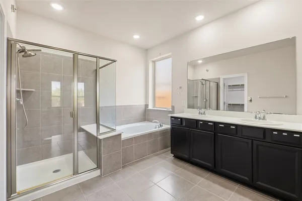 a spacious bathroom with a shower sink and mirror