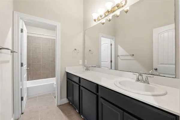 a bathroom with a sink double vanity granite tub and a mirror