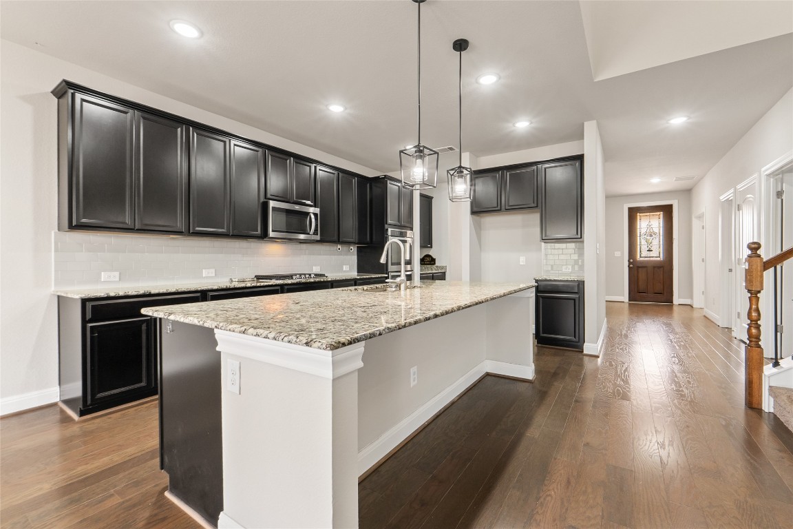 2260 Hat Bender Loop Round Rock, TX 78664 - Photo 7 of 40 a large kitchen with a center island wooden floor stainless steel appliances and cabinets