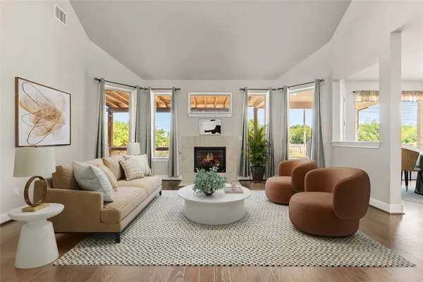 a living room with furniture floor to ceiling window and a fireplace