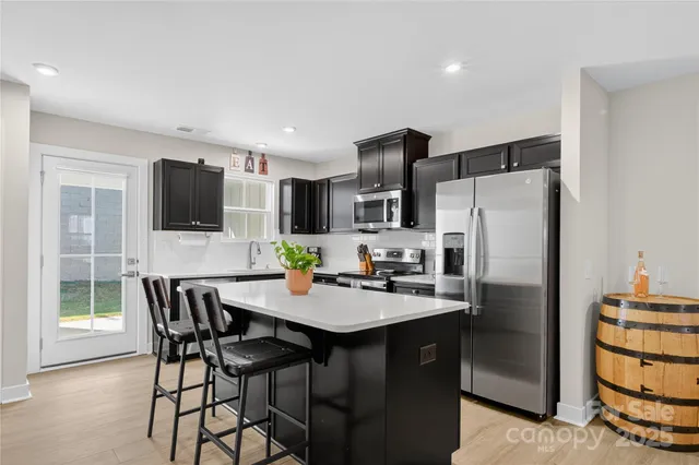 a kitchen with stainless steel appliances a refrigerator stove microwave and cabinets