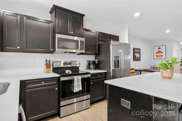 a kitchen with stainless steel appliances and view of refrigerator