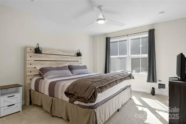 a bedroom with a bed and a flat tv screen on a dresser