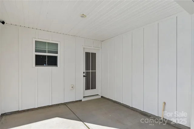 a view of an empty room with closet and entryway