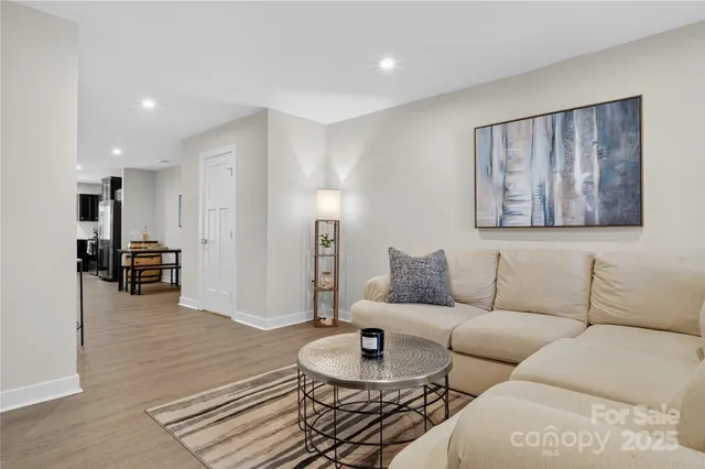 a living room with furniture and a wooden floor