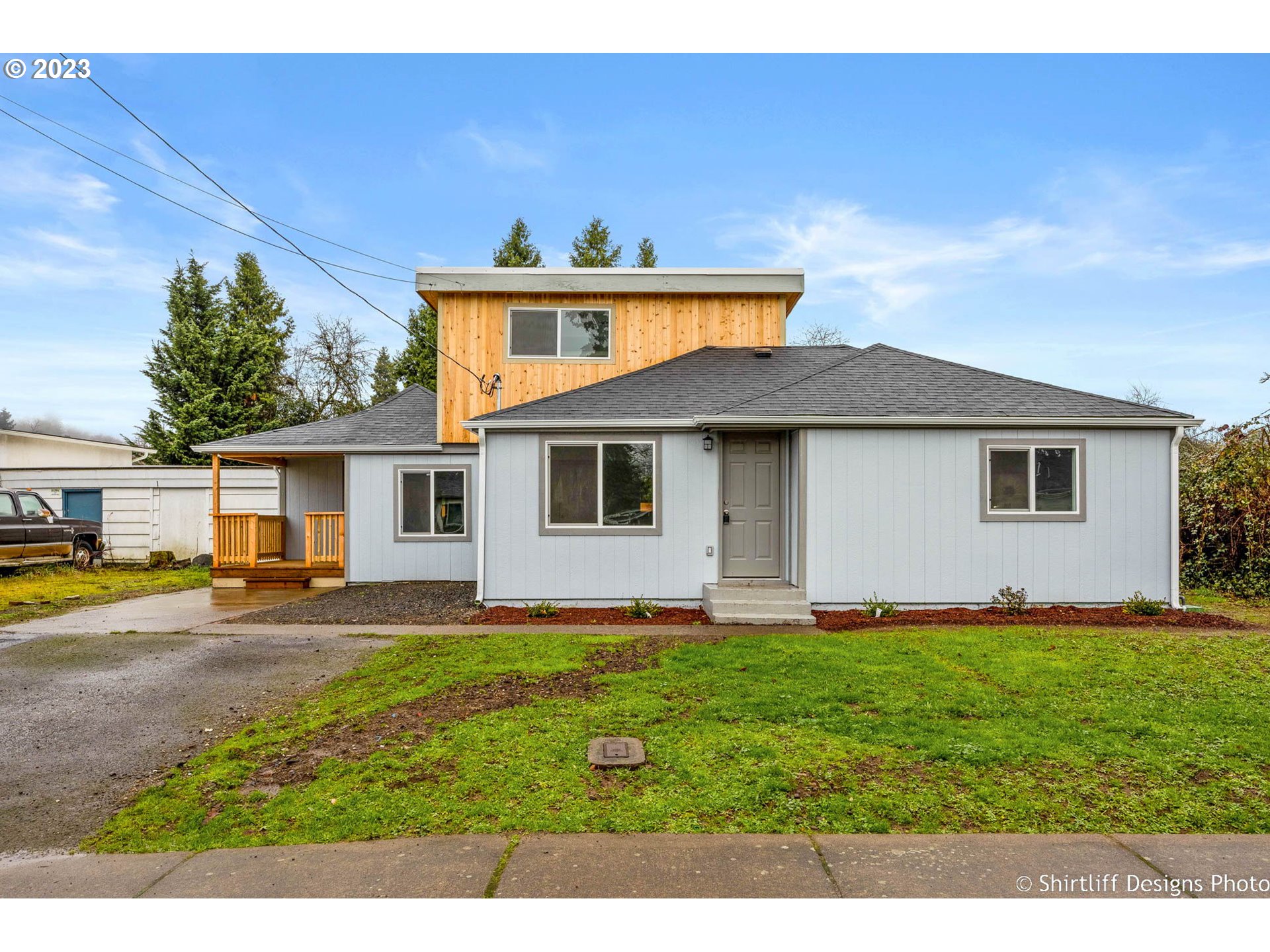 a view of a yard in front of a house with large tree