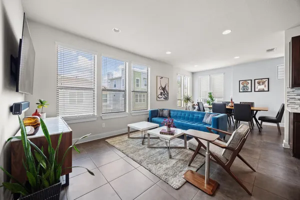 a living room with furniture a flat screen tv and kitchen view